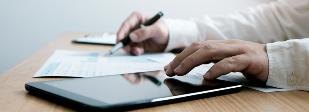 Profissional analisando documentos de compliance e indicadores de risco com apoio de tecnologia, etapa essencial na estruturação de um programa de compliance em 2026.